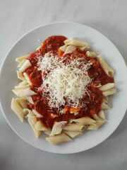 Těstoviny s boloňskou omáčkou sypané sýrem