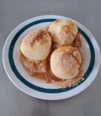 Meruňkové knedlíky sypané strouhaným perníkem, cukrem a máslem